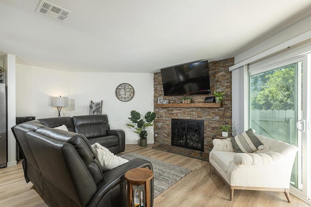 living room with a fireplace and light hardwood / wood-style flooring