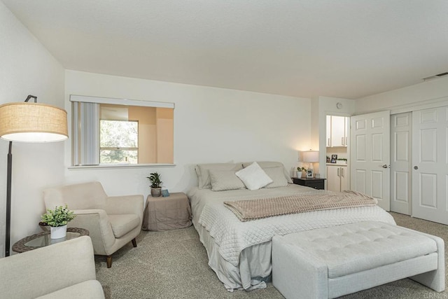 bedroom with light colored carpet and a closet