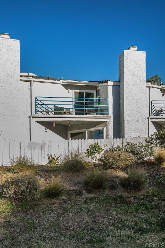 rear view of property featuring a balcony