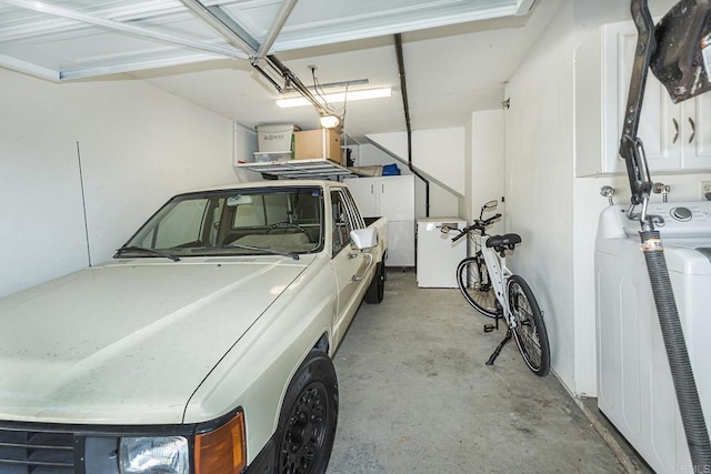 garage with refrigerator and washer and clothes dryer