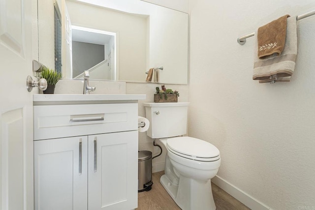 bathroom featuring hardwood / wood-style flooring, vanity, and toilet