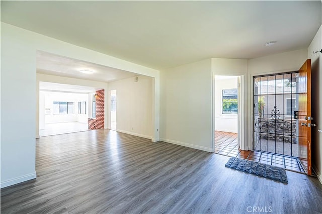 unfurnished living room featuring wood finished floors and baseboards