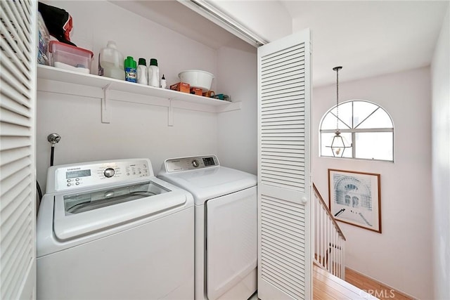 laundry area with light hardwood / wood-style flooring and washing machine and dryer