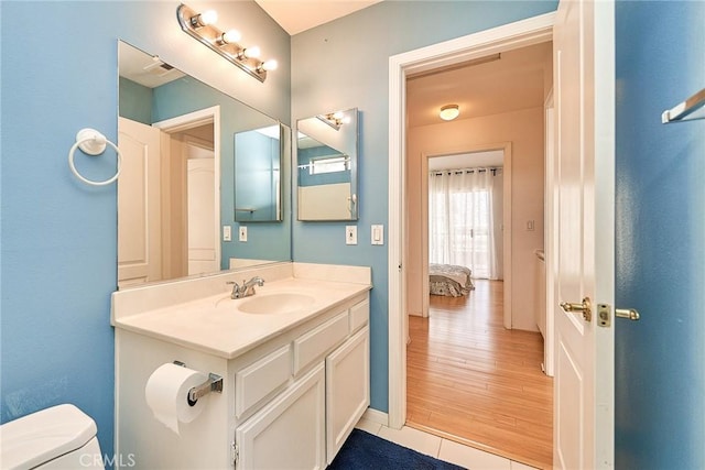 bathroom featuring vanity, tile patterned flooring, and toilet