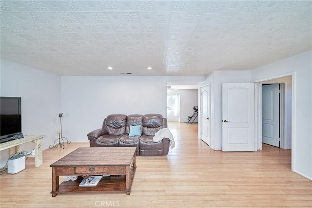 living room featuring a textured ceiling and light hardwood / wood-style flooring