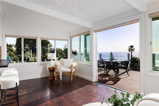 sunroom with a water view, a healthy amount of sunlight, and beamed ceiling