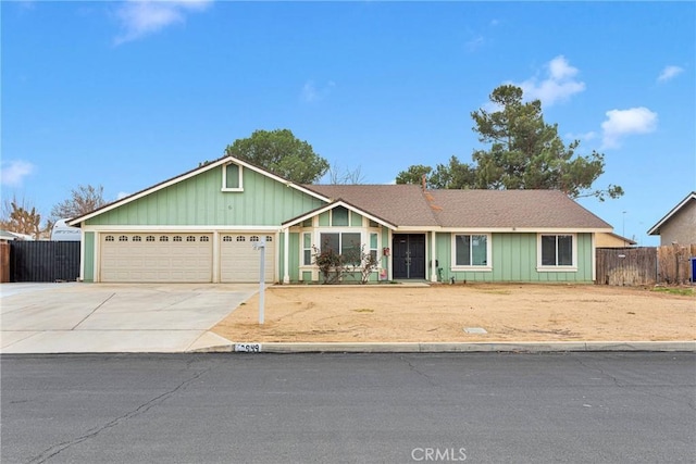 single story home with a garage, driveway, and fence