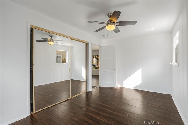 unfurnished bedroom featuring ceiling fan, dark hardwood / wood-style floors, and a closet