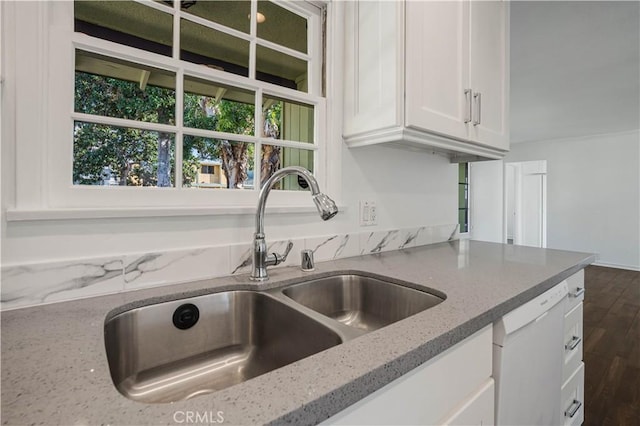 kitchen with sink, white cabinetry, white dishwasher, light stone countertops, and dark hardwood / wood-style flooring