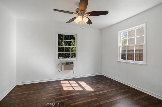 empty room featuring ceiling fan, an AC wall unit, and dark hardwood / wood-style flooring