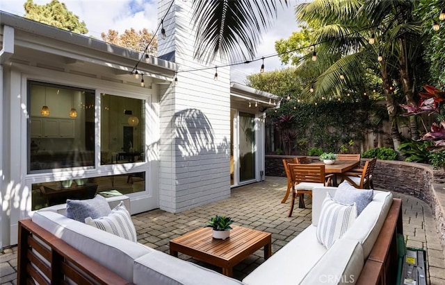 wooden terrace with an outdoor living space and a patio