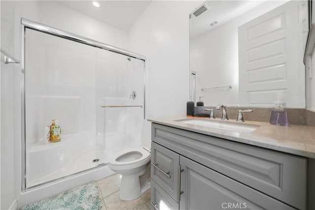 bathroom featuring vanity, toilet, tile patterned flooring, and a shower with door