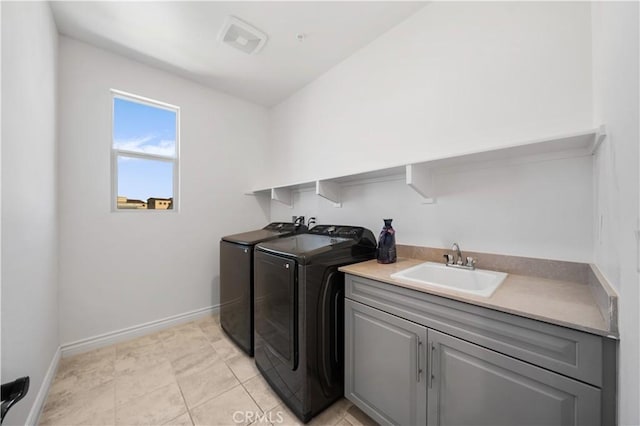 washroom featuring cabinets, light tile patterned flooring, sink, and washing machine and clothes dryer