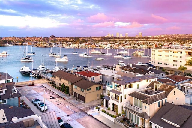 aerial view at dusk featuring a water view