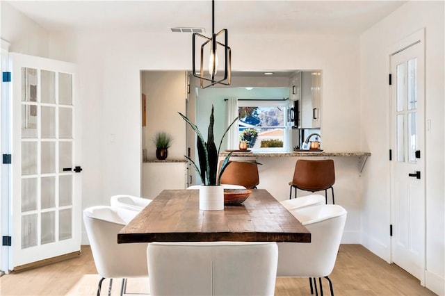 dining space featuring a notable chandelier and light hardwood / wood-style floors