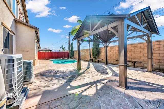 view of patio with a fenced backyard, a fenced in pool, cooling unit, and a gazebo