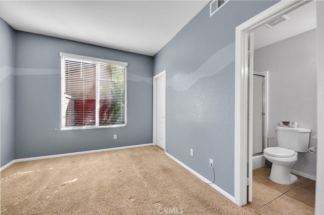 bedroom featuring ensuite bath, baseboards, visible vents, and light colored carpet