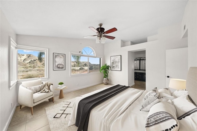 bedroom featuring light tile patterned floors, a ceiling fan, baseboards, and connected bathroom