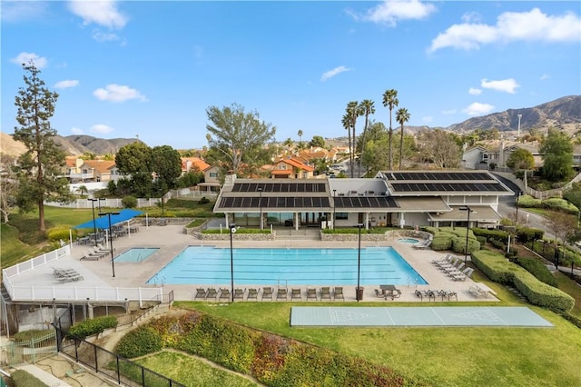 community pool with a patio, a residential view, fence, and a mountain view