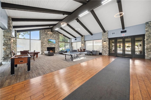 playroom with high vaulted ceiling, a healthy amount of sunlight, a fireplace, and visible vents