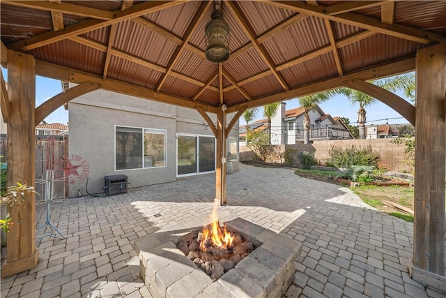 view of patio featuring fence, a fire pit, and a gazebo