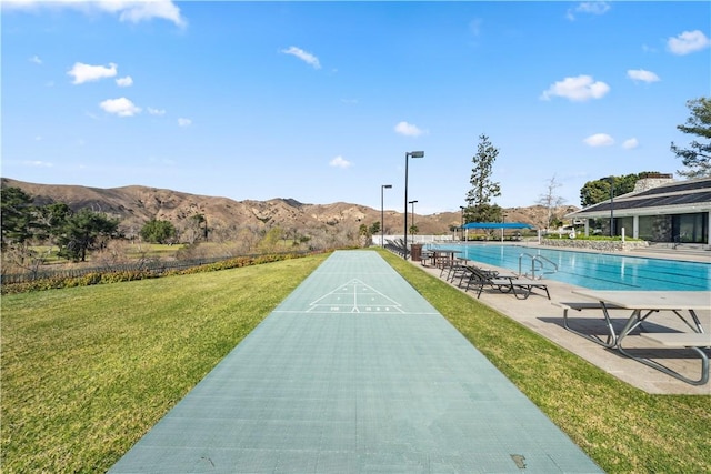 surrounding community featuring shuffleboard, a lawn, and a mountain view