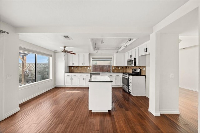 kitchen featuring visible vents, white cabinetry, appliances with stainless steel finishes, tasteful backsplash, and dark countertops