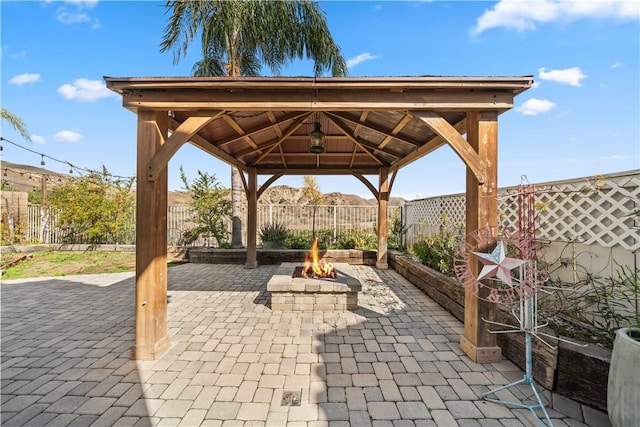 view of patio / terrace featuring a fenced backyard, a fire pit, and a gazebo