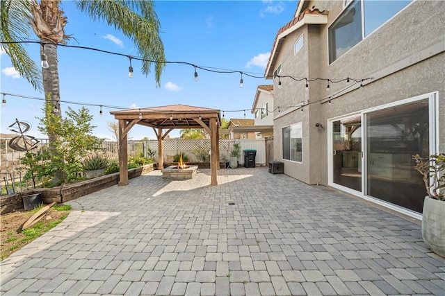 view of patio with a fire pit, a gazebo, and a fenced backyard