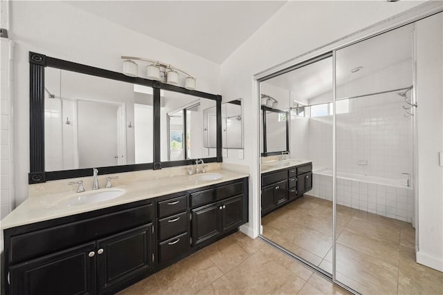 bathroom featuring double vanity, vaulted ceiling, and a sink