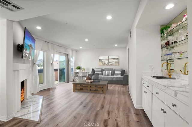 living room featuring wet bar and light wood-type flooring