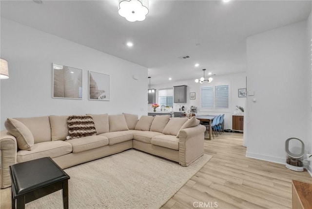 living room with a chandelier and light hardwood / wood-style flooring