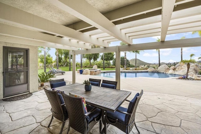 view of patio / terrace with outdoor dining space, an outdoor pool, and an in ground hot tub