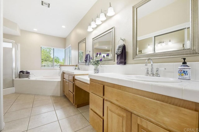 bathroom featuring visible vents, a sink, a bath, and tile patterned floors