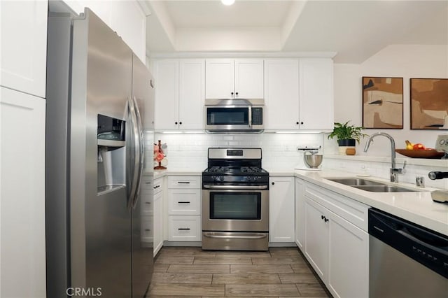 kitchen with white cabinetry, sink, backsplash, and appliances with stainless steel finishes