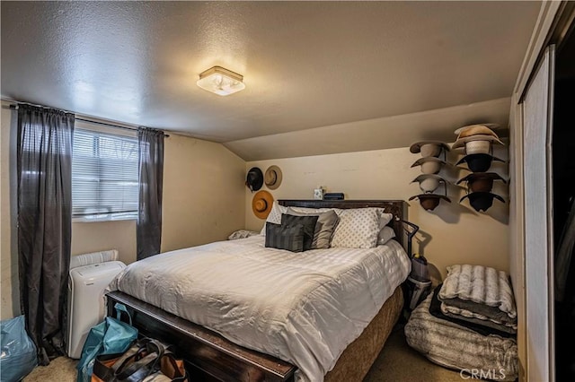 bedroom featuring lofted ceiling, a textured ceiling, and carpet flooring