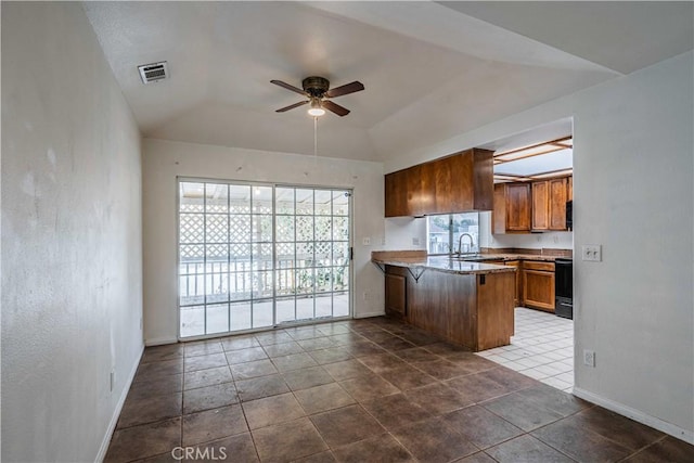 kitchen featuring vaulted ceiling, electric range oven, sink, ceiling fan, and kitchen peninsula