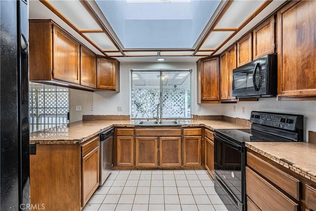 kitchen with light tile patterned flooring, sink, light stone counters, and black appliances