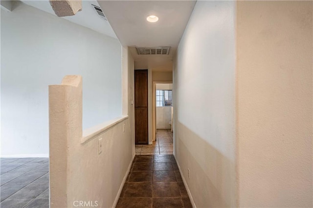 hall featuring dark tile patterned floors