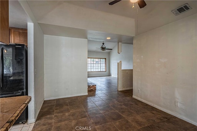 tiled empty room featuring ceiling fan