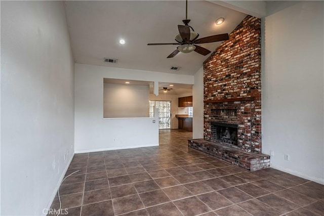 unfurnished living room featuring ceiling fan, a fireplace, high vaulted ceiling, and dark tile patterned floors