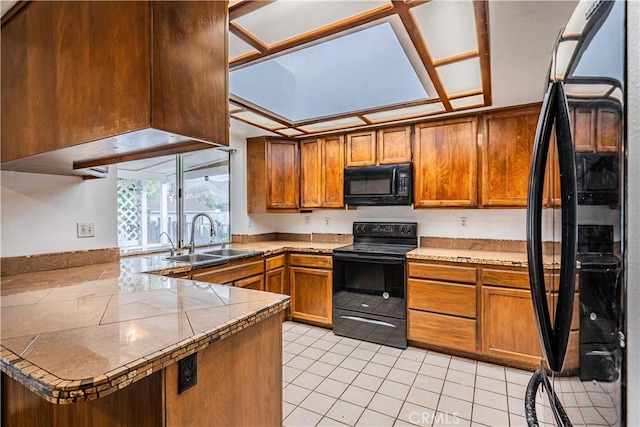 kitchen featuring light tile patterned flooring, kitchen peninsula, sink, and black appliances