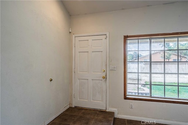 doorway featuring dark tile patterned floors