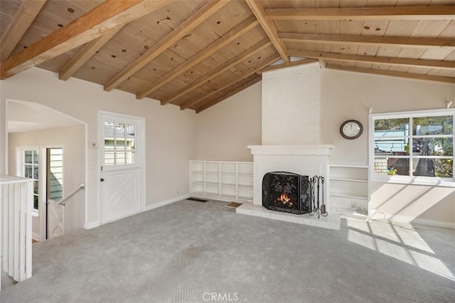 unfurnished living room with lofted ceiling with beams, carpet, wooden ceiling, and a fireplace