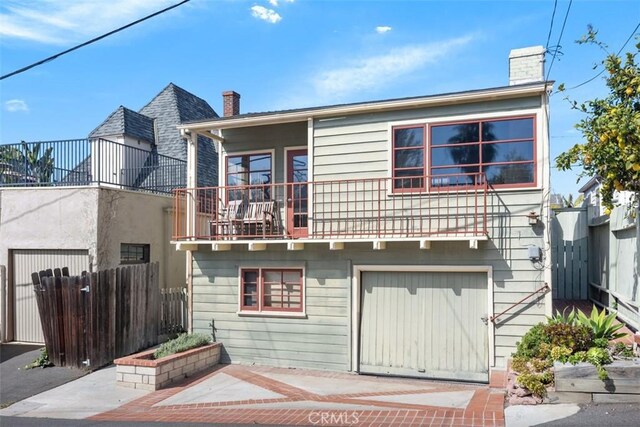 back of house with a garage and a balcony