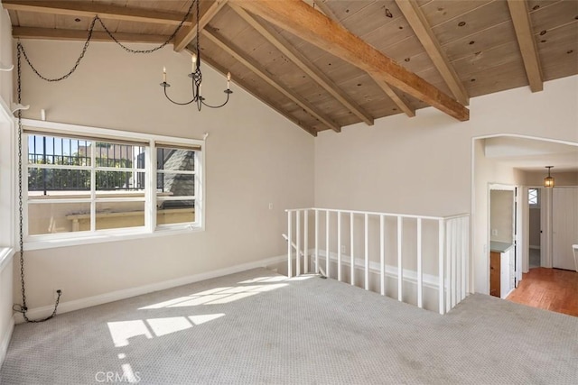 carpeted spare room featuring an inviting chandelier, wood ceiling, high vaulted ceiling, and beamed ceiling