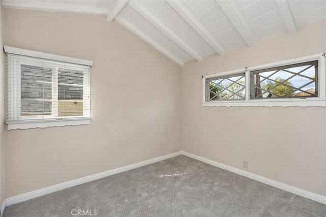 empty room with carpet floors and vaulted ceiling with beams