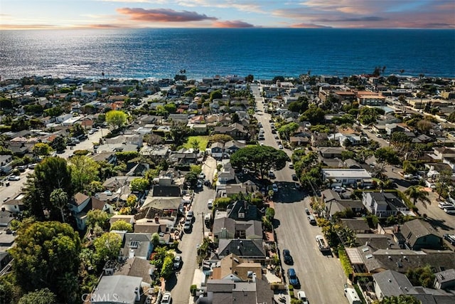 aerial view at dusk featuring a water view