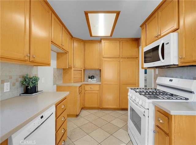 kitchen with white appliances, light countertops, backsplash, and light tile patterned flooring