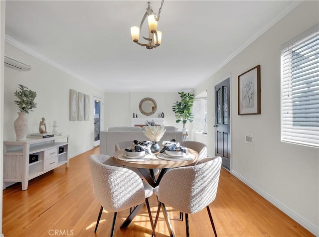 dining space featuring baseboards, an inviting chandelier, light wood-type flooring, crown molding, and visible vents